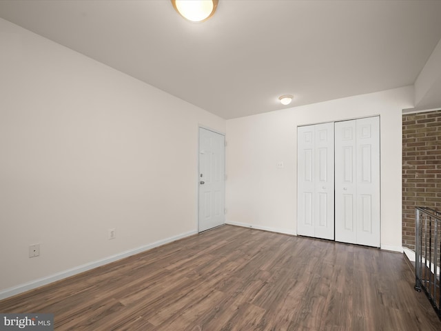 unfurnished bedroom featuring a closet, baseboards, and wood finished floors
