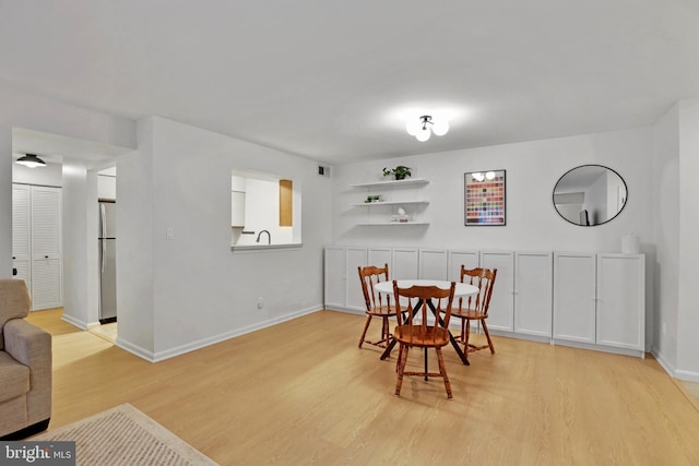 dining space featuring light wood finished floors and baseboards