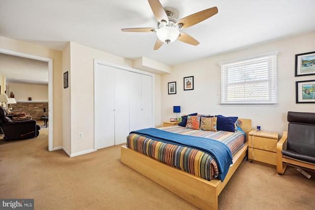 bedroom with light colored carpet, a closet, ceiling fan, and baseboards