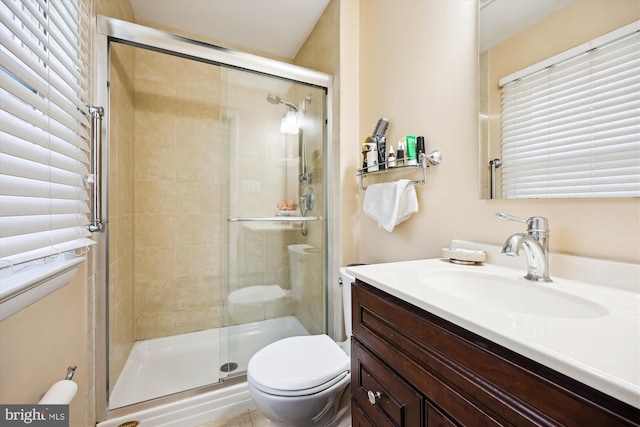 bathroom featuring a stall shower, vanity, and toilet