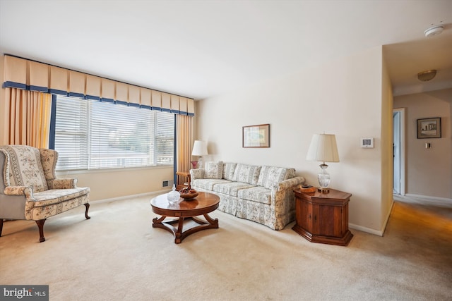 living area with baseboards and carpet