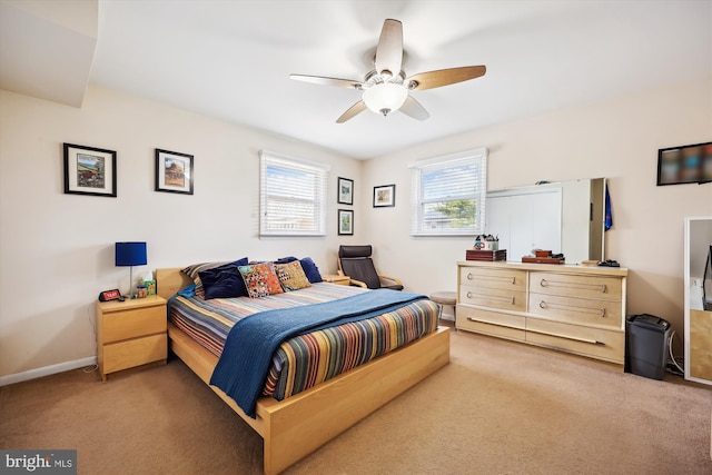 bedroom with light colored carpet, baseboards, and a ceiling fan