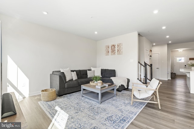 living area featuring stairs, recessed lighting, and wood finished floors