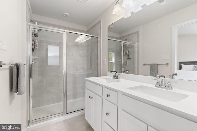 bathroom featuring double vanity, a sink, tile patterned flooring, and a stall shower