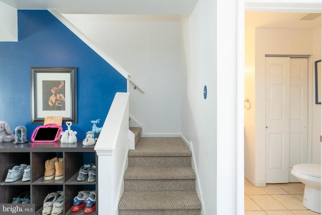 stairs with tile patterned floors, visible vents, and baseboards