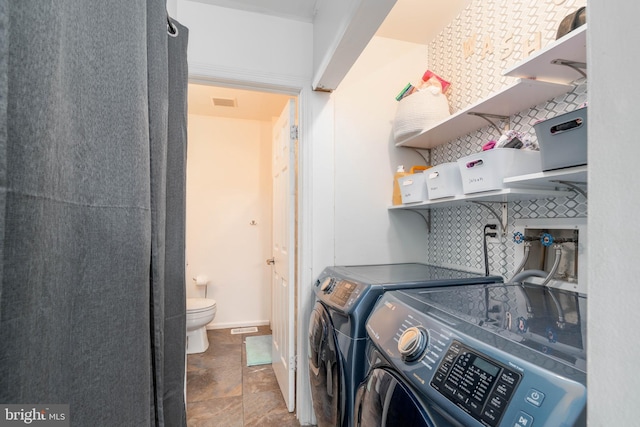 laundry room with washing machine and clothes dryer, baseboards, and laundry area