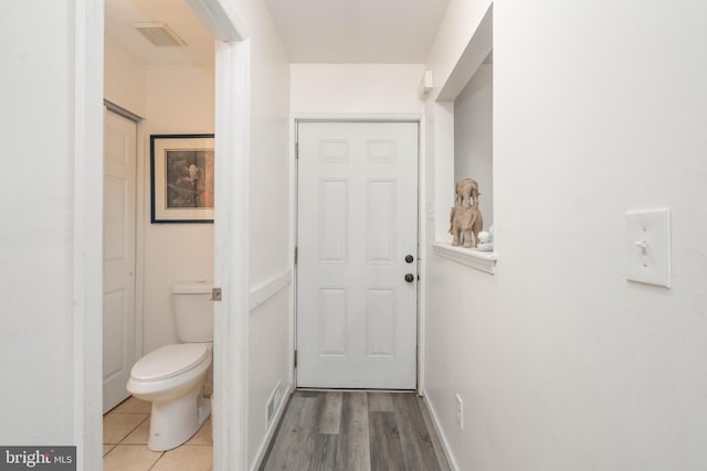 interior space featuring baseboards, visible vents, and light tile patterned floors