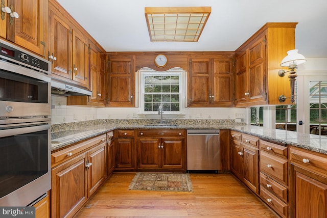 4300 Valleyview Rd, Harrisburg, PA 17112 - kitchen with appliances with stainless steel finishes, a sink, under cabinet range hood, and brown cabinetry