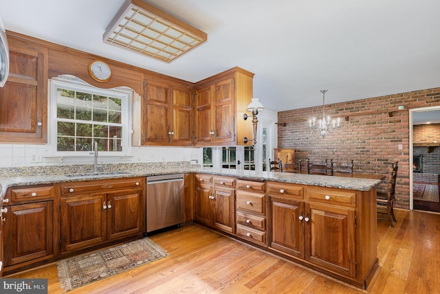 4300 Valleyview Rd, Harrisburg, PA 17112 - kitchen featuring a sink, dishwasher, a chandelier, brick wall, and brown cabinets