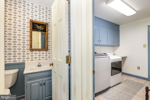 4300 Valleyview Rd, Harrisburg, PA 17112 - laundry area featuring independent washer and dryer, wallpapered walls, cabinet space, light tile patterned floors, and wainscoting