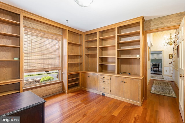 4300 Valleyview Rd, Harrisburg, PA 17112 - unfurnished office featuring light wood finished floors, a chandelier, built in study area, and a fireplace with raised hearth