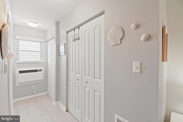 2818 Tern Dr Unit 9, Ocean City, MD 21842 - hallway featuring a wall unit AC, baseboards, and light wood finished floors