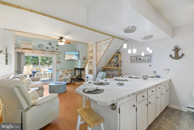 2818 Tern Dr Unit 9, Ocean City, MD 21842 - kitchen with open floor plan, white cabinets, a peninsula, and wood finished floors