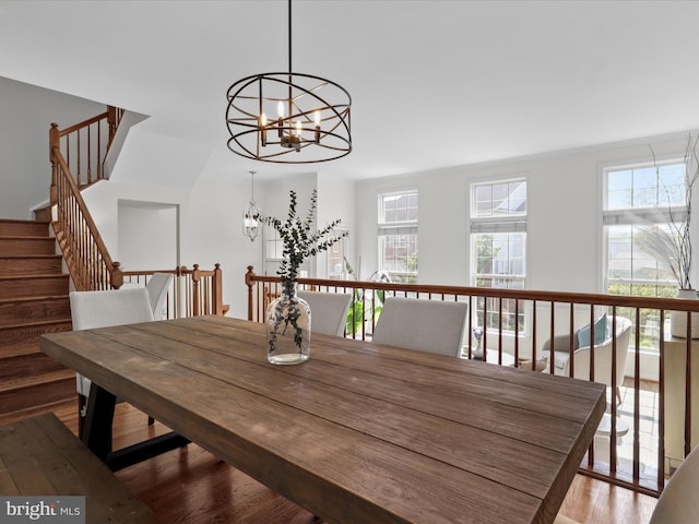 dining room with stairway, wood finished floors, and a chandelier