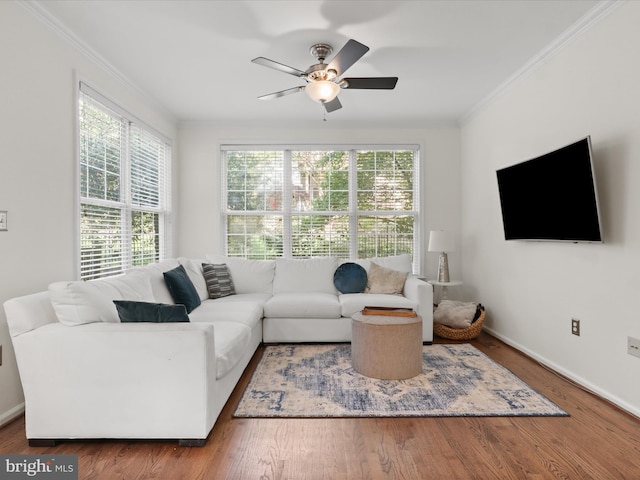living room with crown molding, baseboards, and a ceiling fan