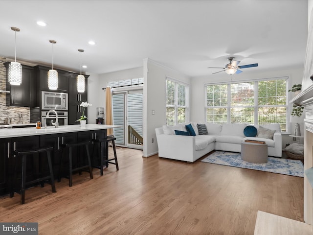 living area featuring recessed lighting, ceiling fan, and light wood finished floors