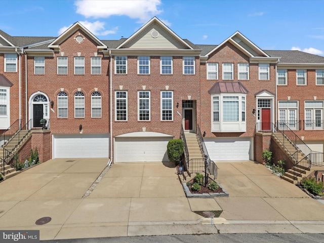 townhome / multi-family property featuring a garage, stairway, and concrete driveway