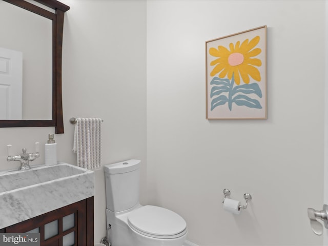 half bathroom with toilet and vanity