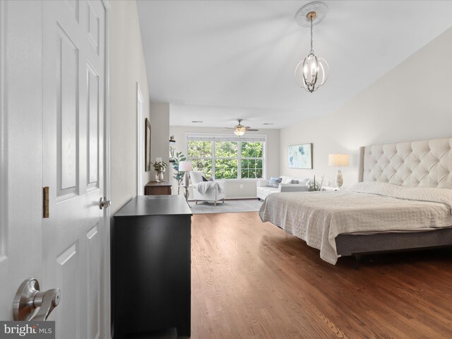 bedroom featuring wood finished floors and a chandelier