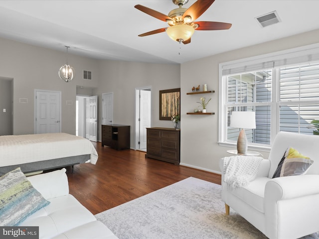 bedroom featuring baseboards, vaulted ceiling, wood finished floors, and visible vents