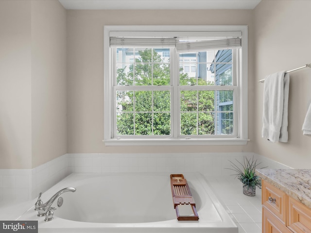 bathroom featuring a wealth of natural light, a bath, and vanity