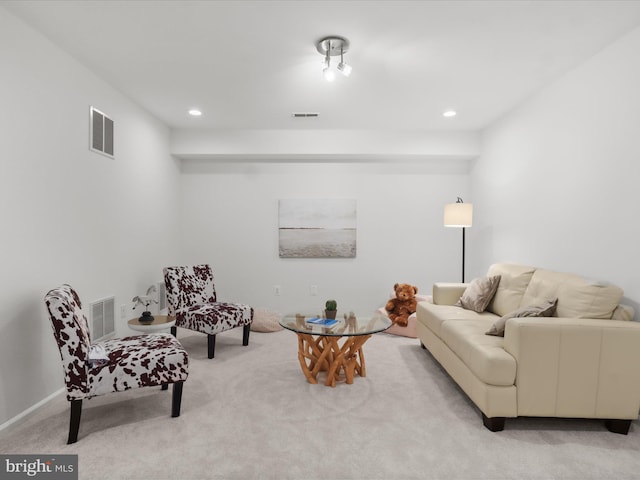 living area featuring light carpet, recessed lighting, and visible vents