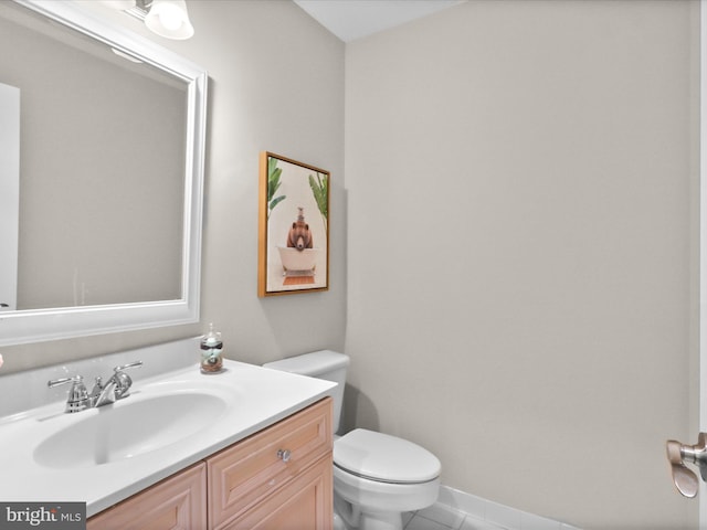half bathroom with toilet, tile patterned flooring, and vanity