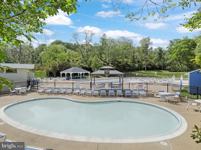 pool featuring fence, a patio, and a gazebo
