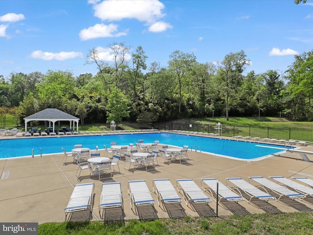 community pool featuring fence, a gazebo, and a patio area