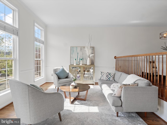 living area with crown molding, baseboards, and wood finished floors