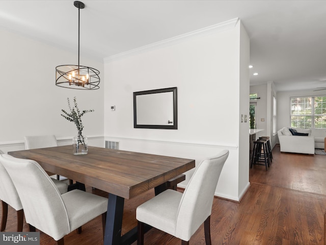 dining room featuring a notable chandelier, recessed lighting, wood finished floors, visible vents, and ornamental molding