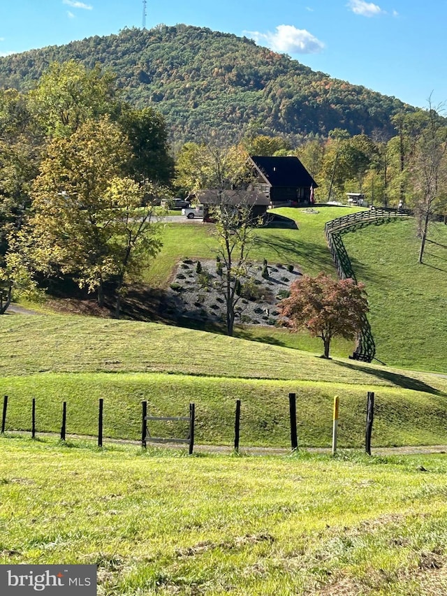 surrounding community featuring a mountain view, a yard, and a rural view