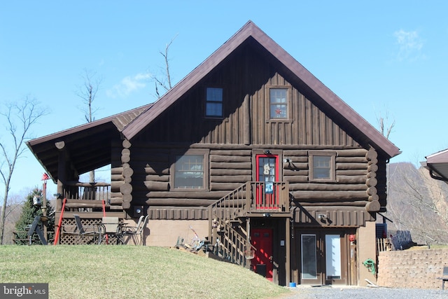 log cabin featuring log siding, a front lawn, and board and batten siding