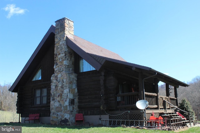 exterior space with a chimney and log siding