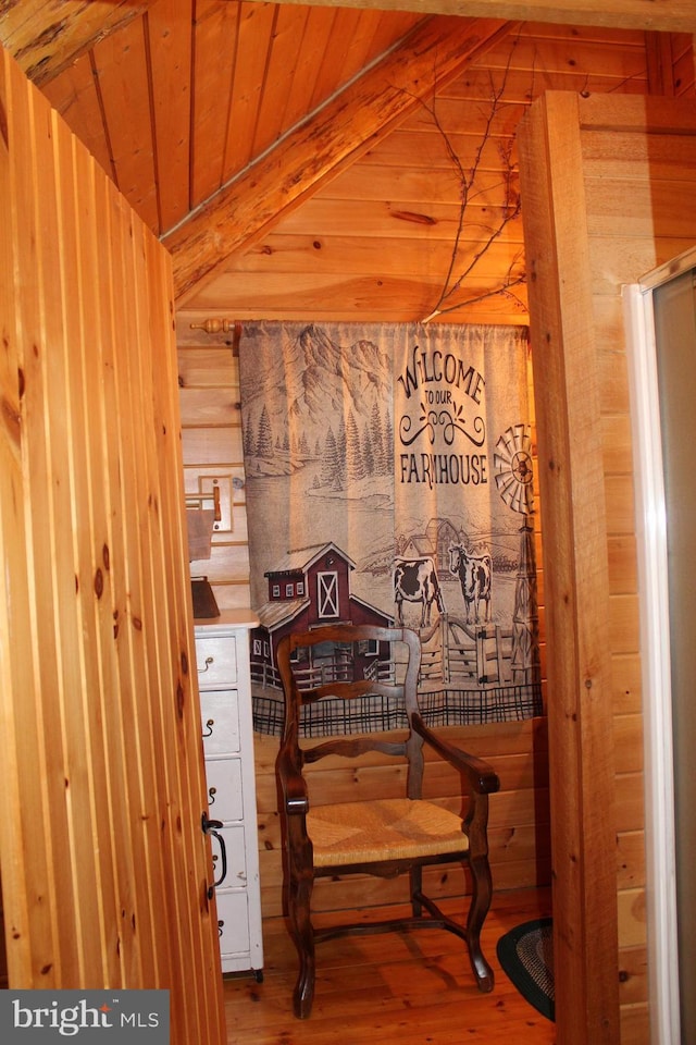 interior space with beamed ceiling, wood finished floors, wood walls, and wood ceiling