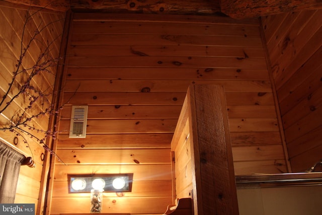 staircase with visible vents, wood walls, and a sauna