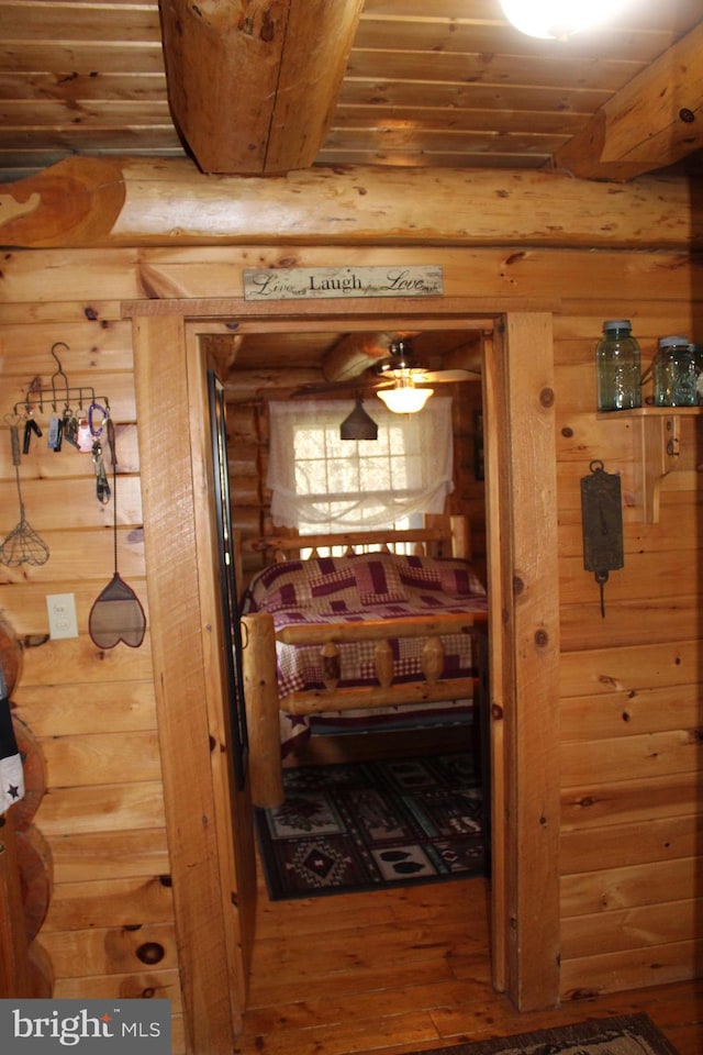 hallway with hardwood / wood-style floors, log walls, wood walls, and wood ceiling