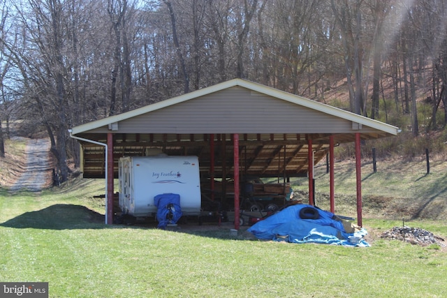 view of pole building featuring driveway, a yard, and a carport