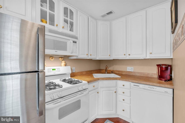 kitchen featuring a sink, glass insert cabinets, white appliances, visible vents, and white cabinets