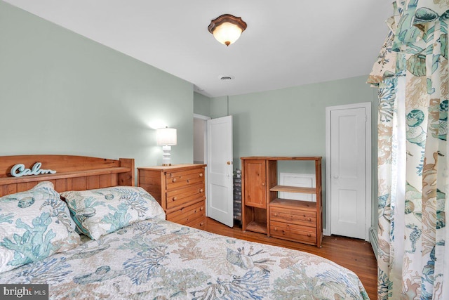 bedroom featuring visible vents and wood finished floors