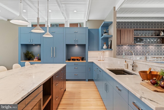 7030 Oregon Ave NW, Washington, DC 20015 - kitchen featuring open shelves, light wood-style flooring, a sink, and blue cabinets