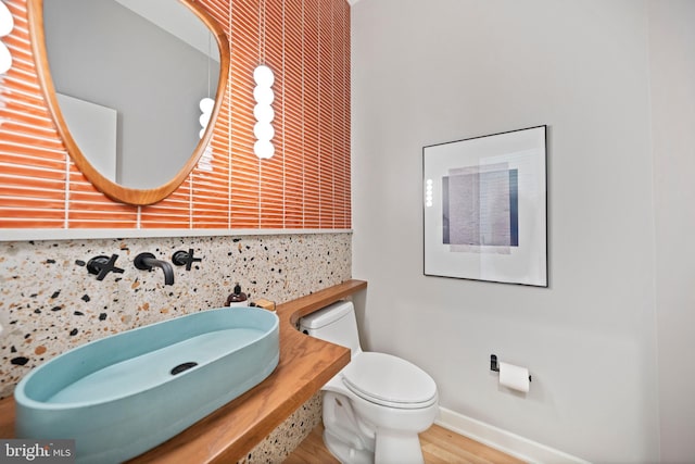 7030 Oregon Ave NW, Washington, DC 20015 - bathroom featuring decorative backsplash, baseboards, wood finished floors, and toilet
