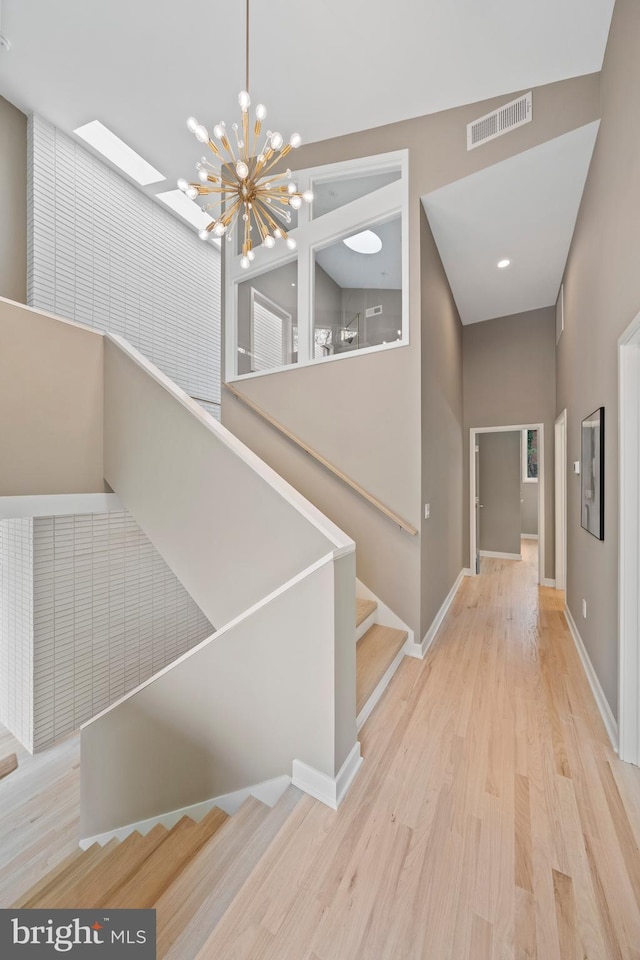 7030 Oregon Ave NW, Washington, DC 20015 - stairway featuring a chandelier, wood finished floors, visible vents, and baseboards
