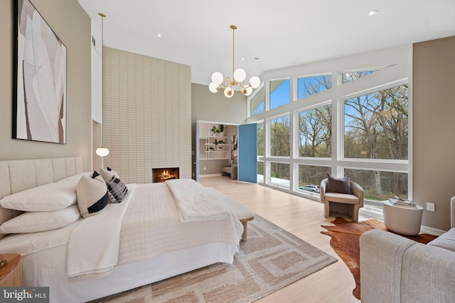 7030 Oregon Ave NW, Washington, DC 20015 - bedroom featuring wood finished floors, a towering ceiling, a fireplace, a notable chandelier, and recessed lighting