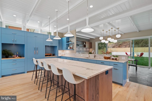 7030 Oregon Ave NW, Washington, DC 20015 - kitchen featuring open shelves, light wood-type flooring, blue cabinets, and a sink