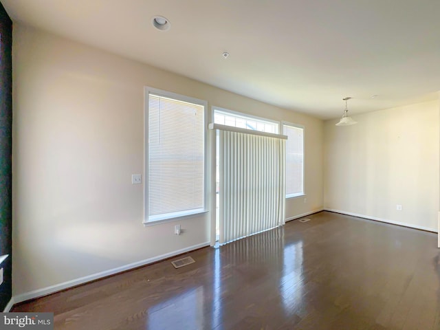 unfurnished room featuring baseboards, visible vents, wood finished floors, and recessed lighting