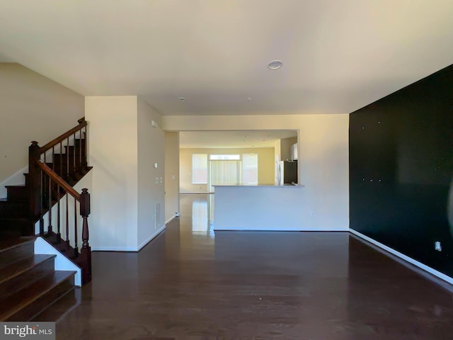 spare room featuring baseboards and stairs
