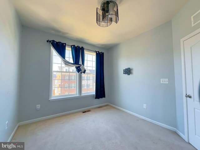 carpeted spare room with baseboards and visible vents