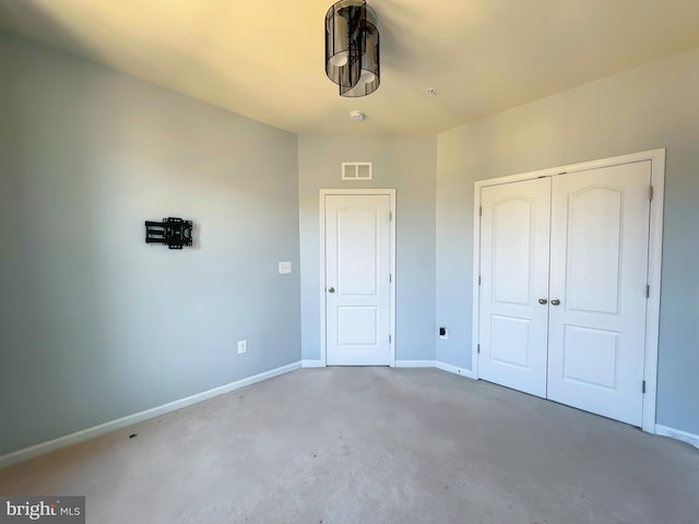 unfurnished bedroom with baseboards, visible vents, a closet, and concrete floors