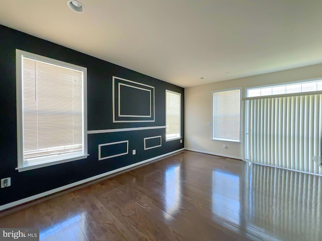 empty room featuring baseboards and wood finished floors